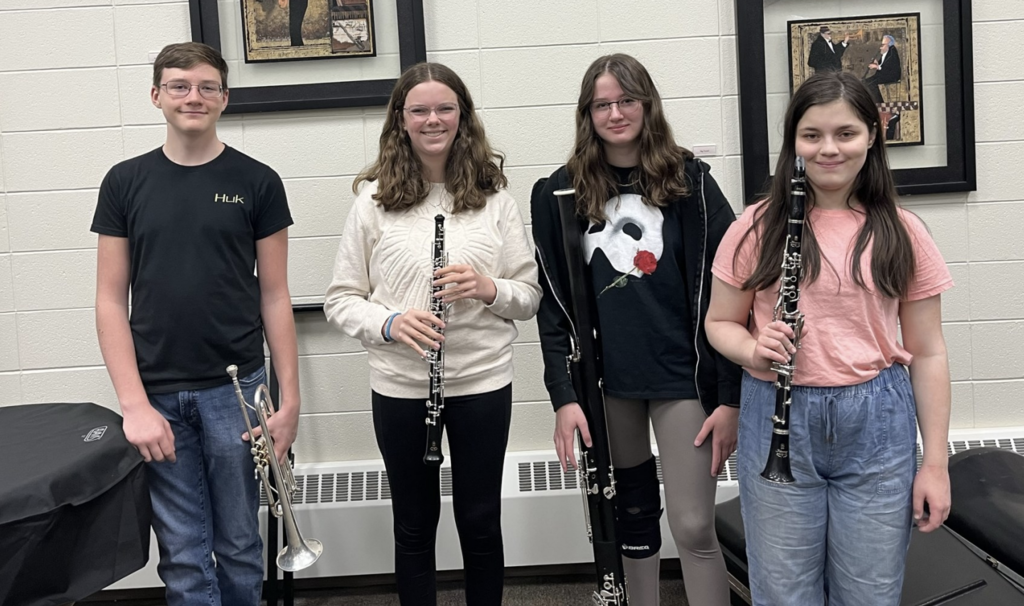 four students pose with their instruments